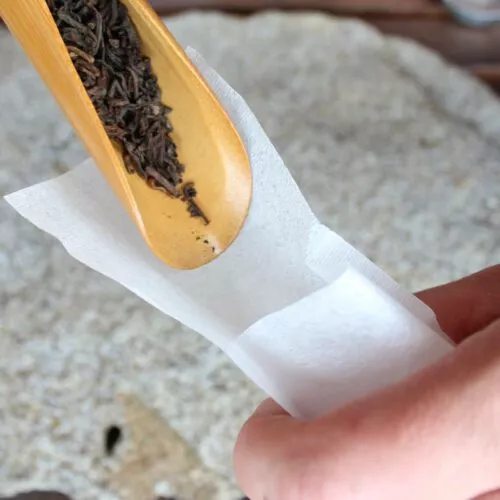 remplissage de thé dans le filtre en papier